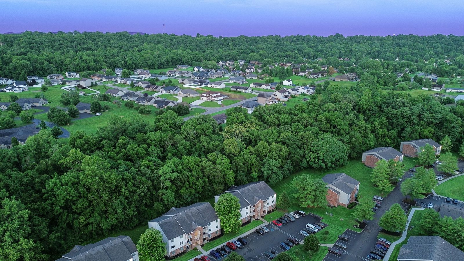 Aerial view of garden apartment buildings surrounded by trees